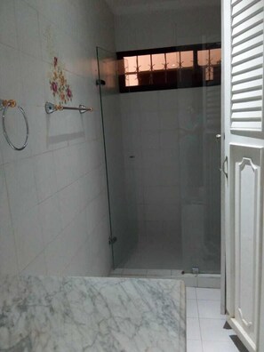 Een douche, handdoeken, zeep, toiletpapier