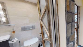 A modern bathroom with a toilet, sink, and shower.