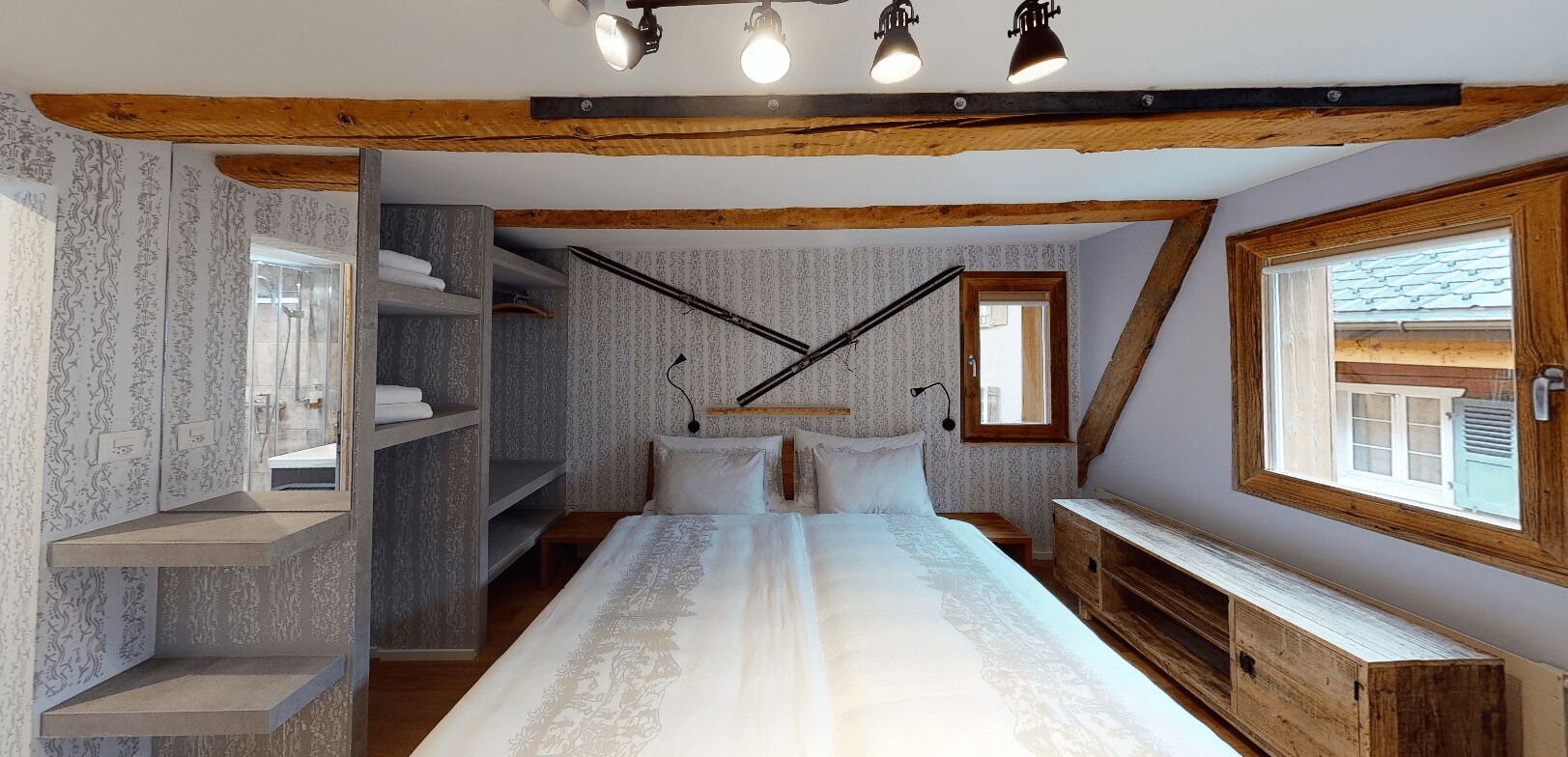 Un dormitorio con una cama grande, estanterías empotradas, un escritorio y una ventana con vistas.