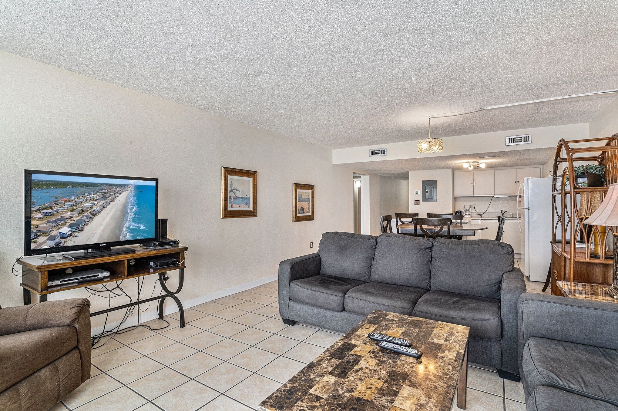 A living room with a television, grey sofa, and a coffee table.