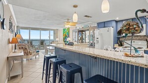 A kitchen with a bar area, a ceiling fan, and a view to the outside. - 0801 Waters Edge Resort 3 Bedroom Condo by RedAwning (Murrells Inlet)