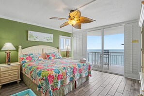 A bedroom with a bed, a ceiling fan, a nightstand, a lamp, a window, and a balcony with a view. - 0801 Waters Edge Resort 3 Bedroom Condo by RedAwning (Murrells Inlet)