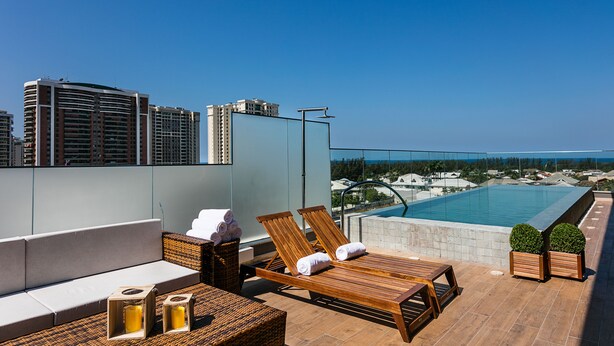 A rooftop terrace with lounge chairs, a small pool, and a city view. - SQUARE DESIGN HOTEL (Rio de Janeiro)