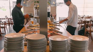 A buffet setup with multiple stacks of plates and serving utensils.