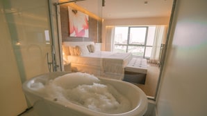 A modern bathroom with a bathtub, a shower, and a large window offering a city view. - SQUARE DESIGN HOTEL (Rio de Janeiro)