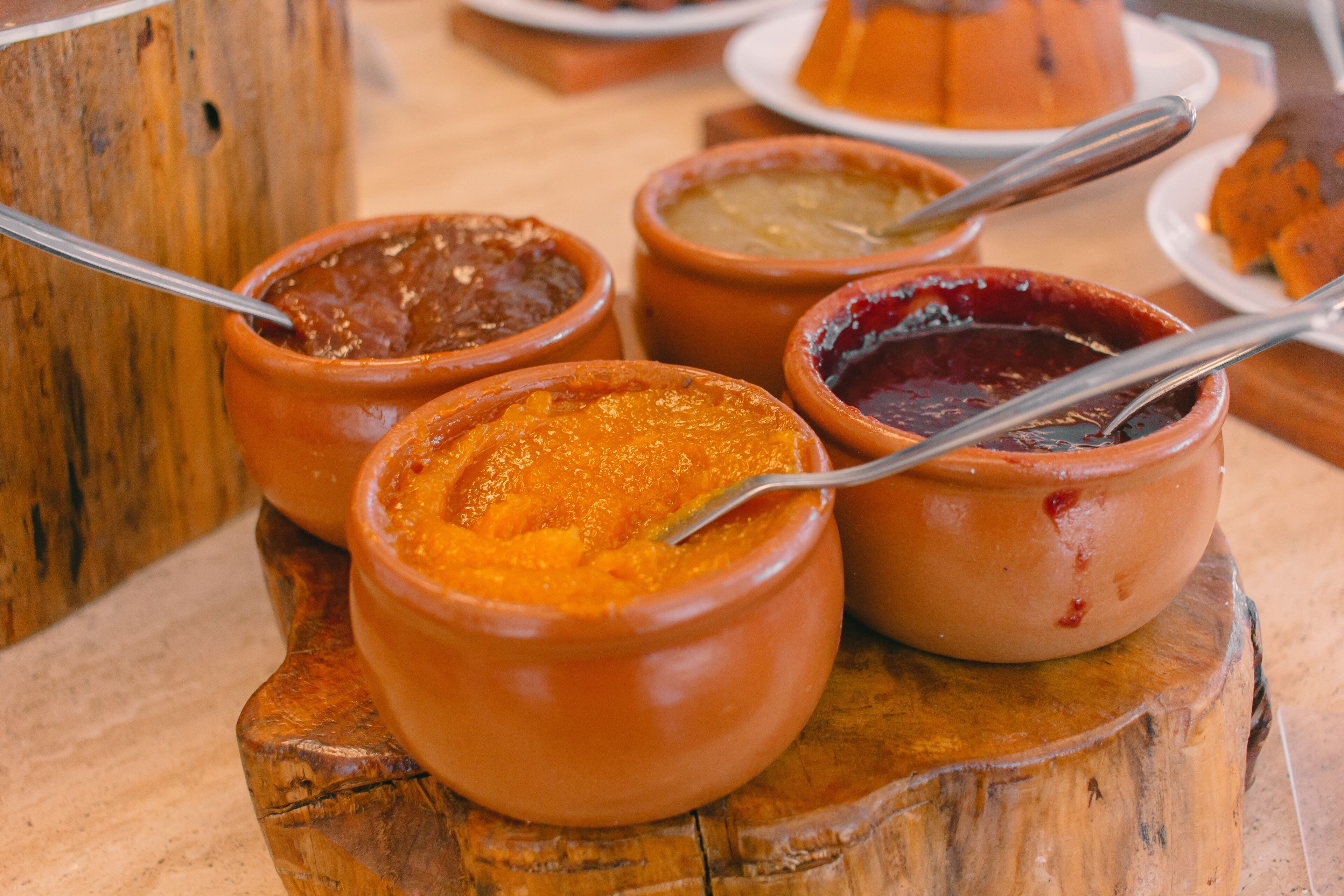 Una mesa de madera con varios cuencos de terracota que contienen distintos tipos de comida.