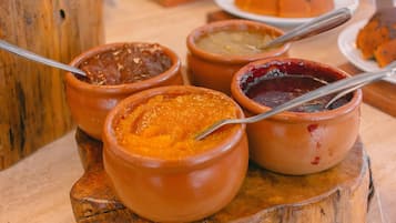 A wooden table with several terracotta bowls containing different types of food.