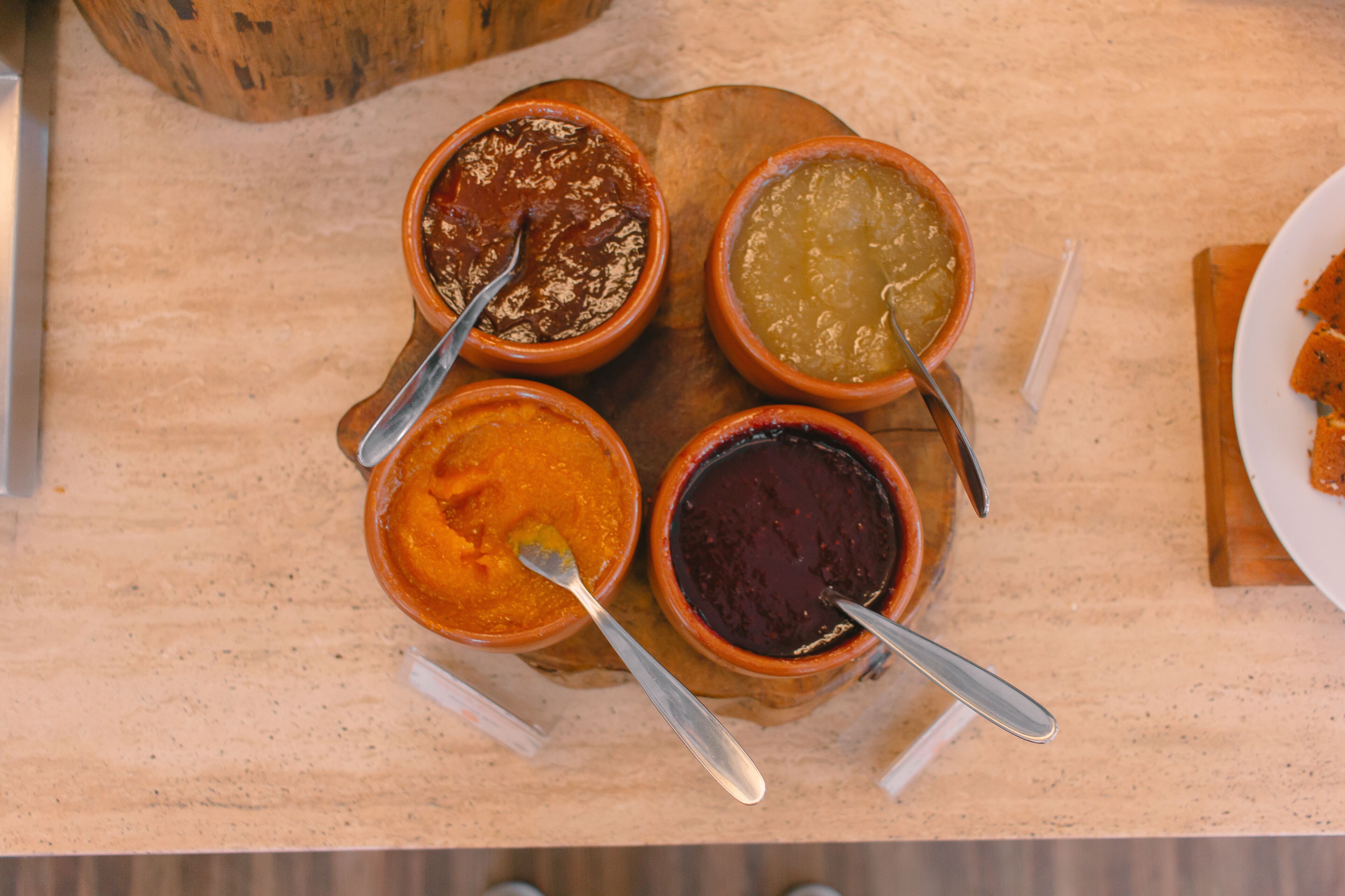 Cuatro recipientes con salsas diferentes sobre una tabla de madera.