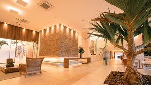 A spacious lobby with a reception desk, seating area, and a large palm tree. - SQUARE DESIGN HOTEL (Rio de Janeiro)