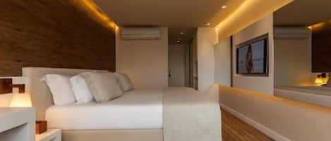 Un dormitorio moderno con cama, mesita de noche y un espejo grande.