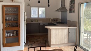 Cuina moderna amb un armari de fusta, un fogó integrat i una finestra.