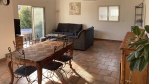 Un espai saló ample amb una taula de dinar de fusta, un sofà i una televisió.
