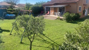 Una casa amb terrassa, piscina i un jardí petit.