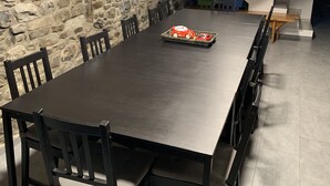A dining area with a stone wall, a long table with chairs, and a staircase leading to another level. - House with a different style for families and groups (Biescas)