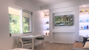 A modern room with a bed, a desk, and a TV.