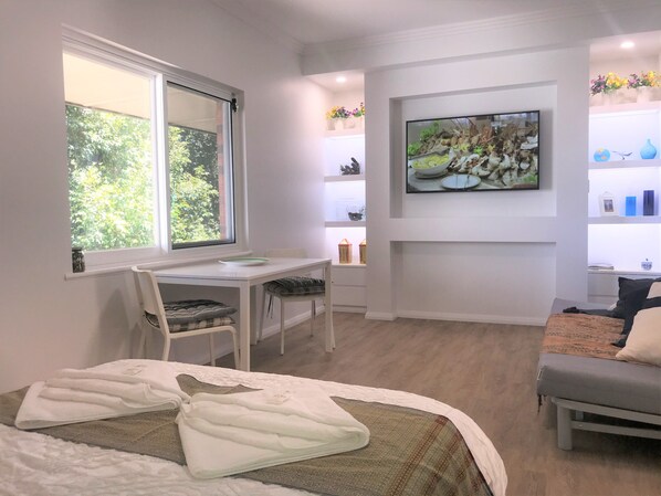 A modern room with a bed, a desk, and a TV. - M207 Studio Apartment on Malcolm Street (West Perth)