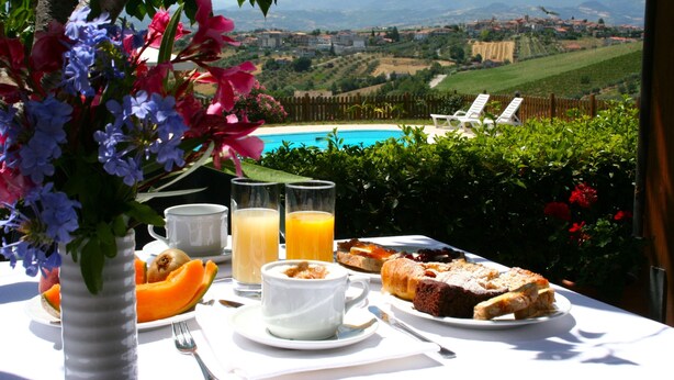 Une table de petit-déjeuner avec vue sur une piscine et des montagnes.