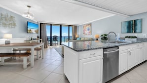 A modern kitchen with white cabinetry, a granite countertop, and a stainless steel dishwasher.