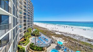 A high-rise hotel with a rooftop pool and beach view.