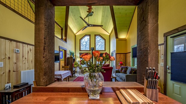 A wooden dining table with a vase of flowers and a knife block. - Handicap Accessible cottage at Desoto Falls Mentone, AL  Central Time Zone (Mentone)