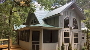 A cabin with a covered porch and large windows, surrounded by trees. - Handicap Accessible cottage at Desoto Falls Mentone, AL  Central Time Zone (Mentone)