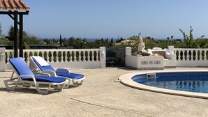 A pool area with blue lounge chairs and a statue. - Traditional Portuguese house with lot of privacy and space. (Carvoeiro lagoa)