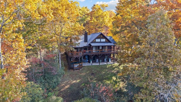 A log cabin with a balcony and multiple levels, surrounded by autumn foliage. - Beautiful Views of The Great Smoky Mountains From Anywhere Indoors or Out! (Bryson City)