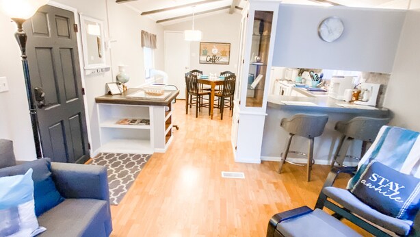 Un salón amplio con un sofá, una mesa de centro y una zona de comedor con mesa y sillas.