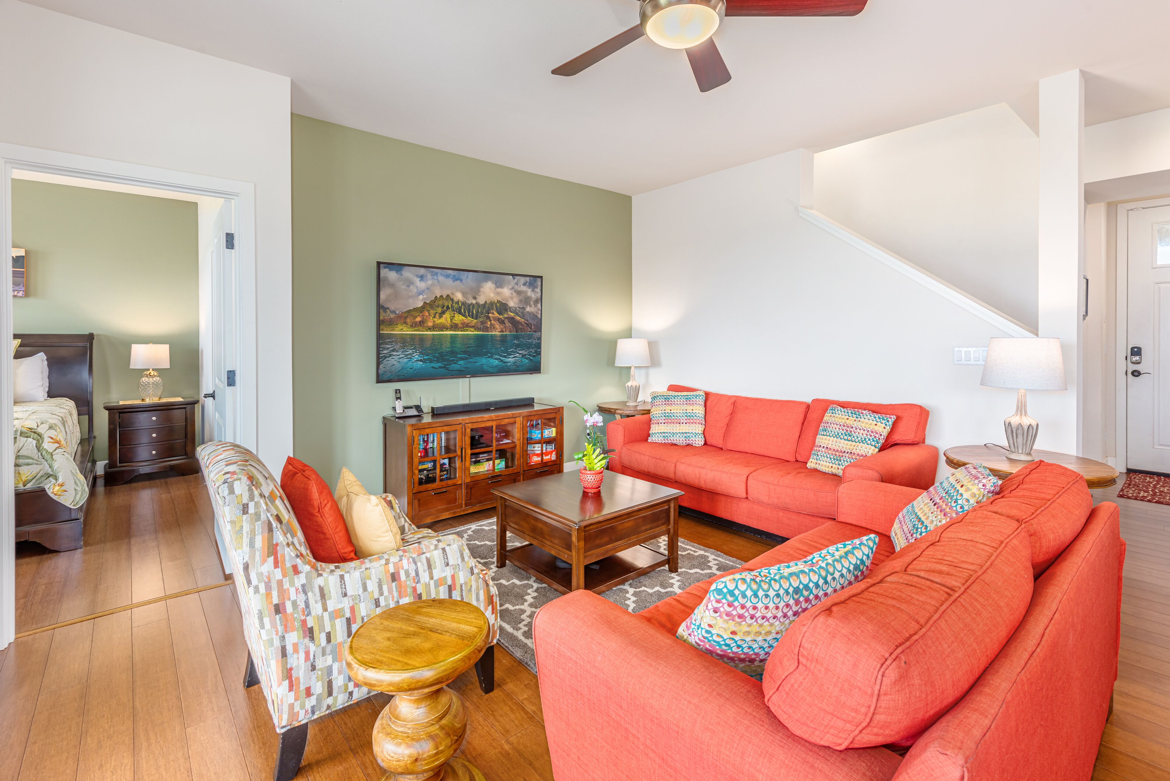 A living room with a sofa, armchair, coffee table, and a painting on the wall.