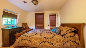 Une chambre à coucher avec un grand lit, une commode, une fenêtre et une porte.