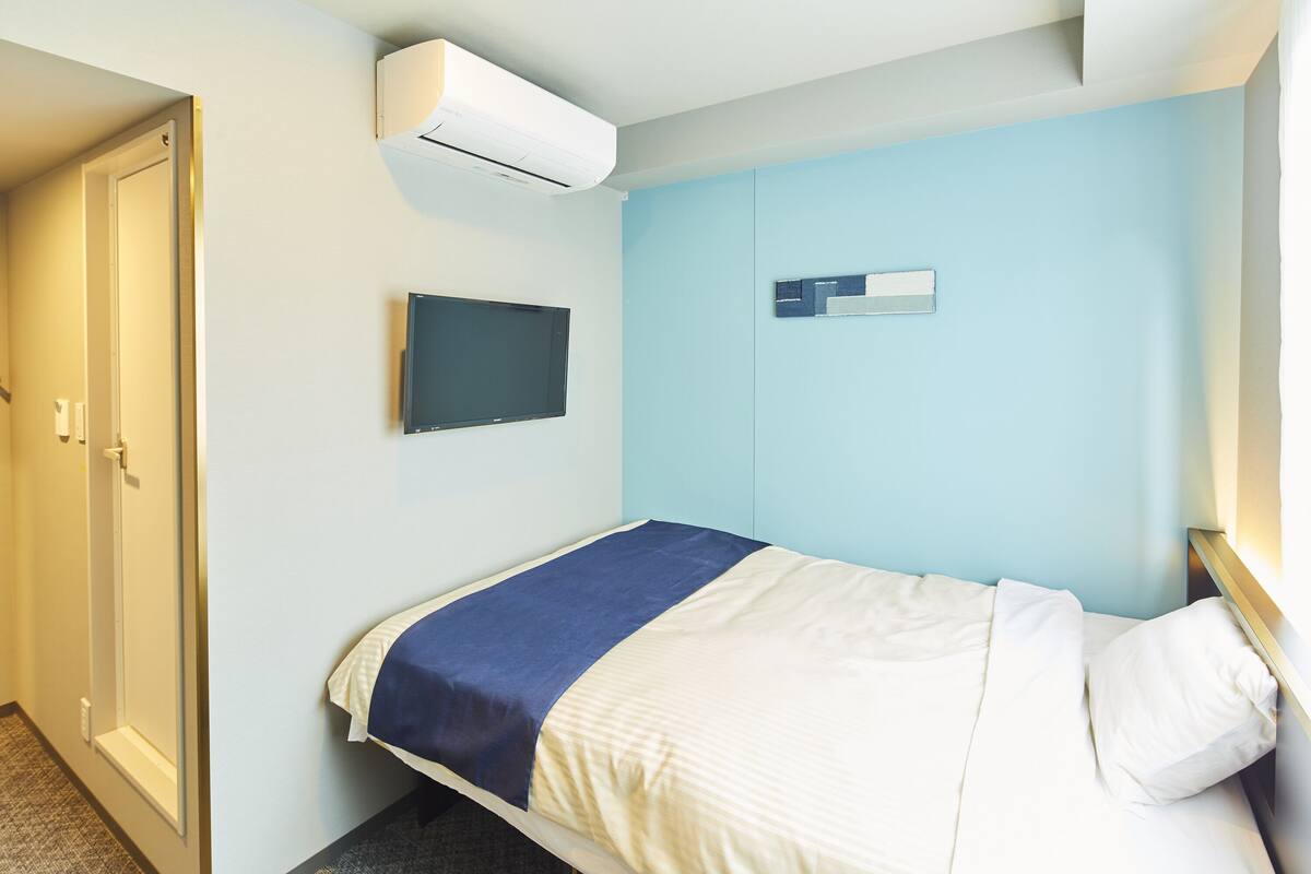 Une chambre d’hôtel équipée d’un lit, d’une t élévision et d’un appareil de climatisation.