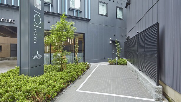 Une entrée d’hôtel moderne avec une enseigne indiquant « HÔTEL » et « EASY POINT ».