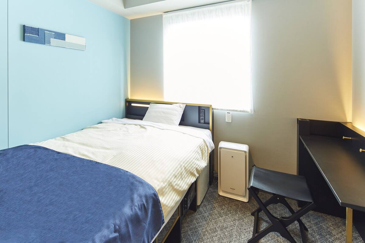 Une chambre à coucher avec un lit, un bureau et une fenêtre.