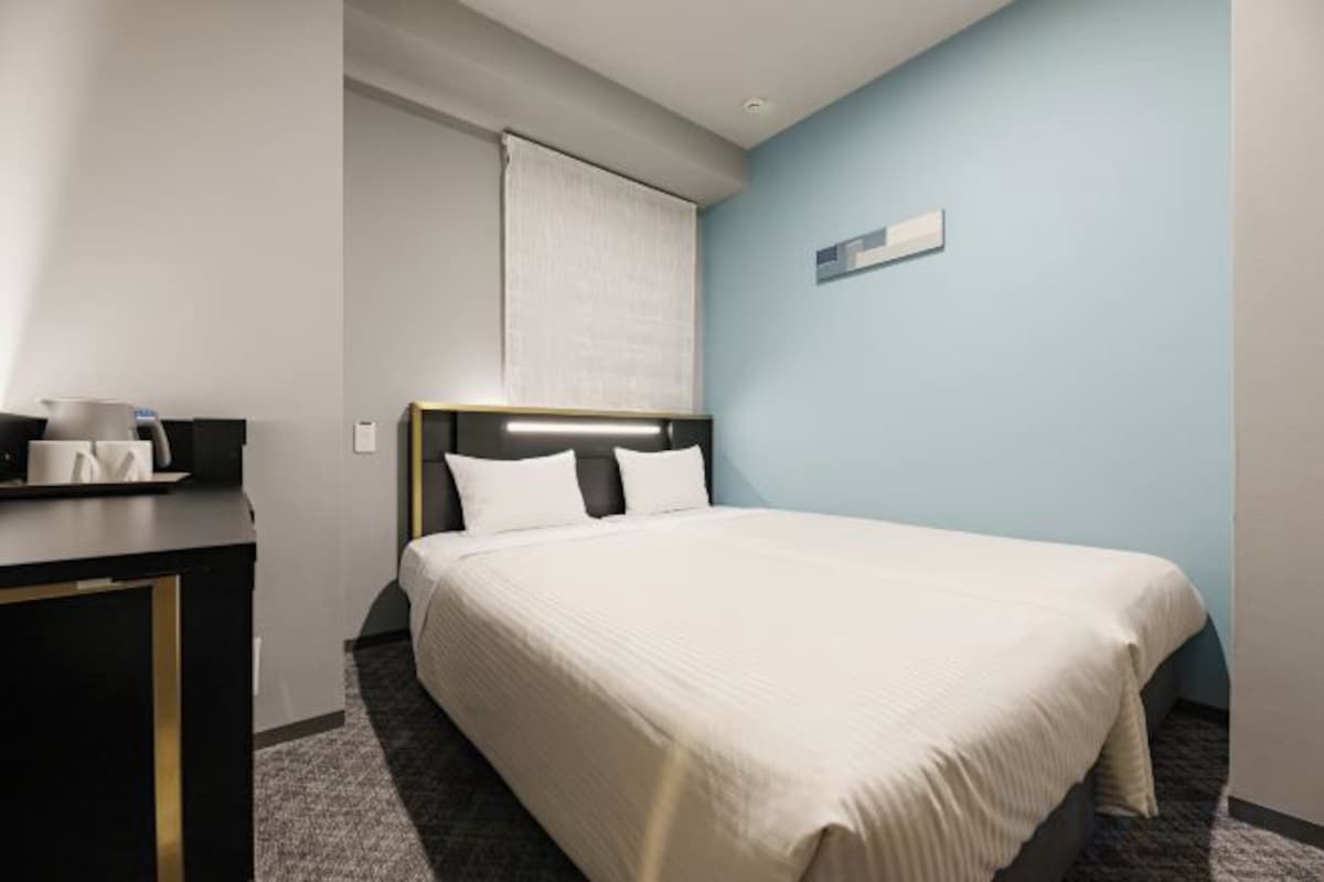 Ein Hotelzimmer mit Bett, Schreibtisch und Nachttisch.