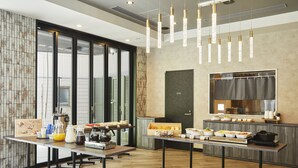 Une cuisine moderne dotée d’un long comptoir, de divers appareils électroménagers et d’une grande fenêtre.