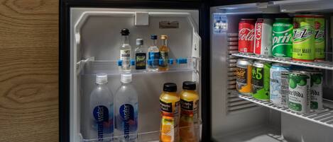 Un refrigerador lleno de bebidas, como agua, refrescos y jugo.