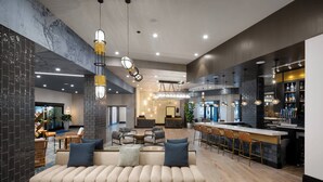 A modern interior with a sofa, bar area, and seating. - Luminary Hotel & Co., Autograph Collection (Fort Myers)