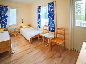 Een kamer met twee bedden, een tafeltje en een stoel.