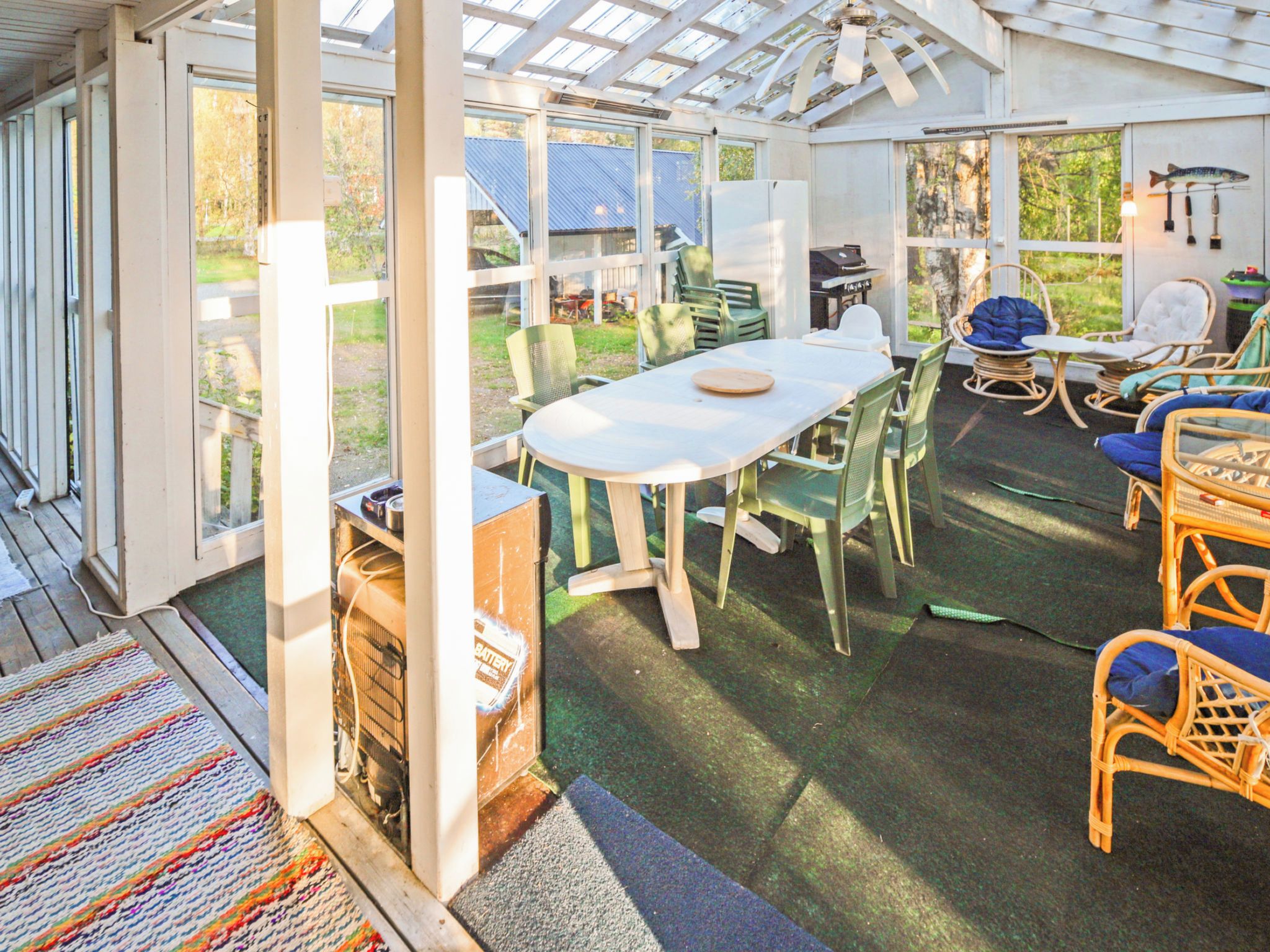 Un patio aménagé, avec une table et des chaises, un barbecue et des meubles en osier.