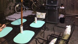 An outdoor patio area with a blue umbrella, a grill, a bicycle, and seating with cushions. - Spacious home in the Heart of Downtown Newport! Walk Everywhere  (Newport)