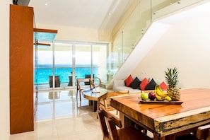 Enjoy meals in this dining area with a sofa and table, offering a balcony with ocean views.