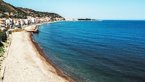 A coastal town with a beach, buildings along the shore, and a clear blue sea. - Apartment Nina by Interhome (Marina di Caronia)
