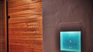 Una puerta de madera con un pared texturizada y un objeto enmarcado sobre fondo azul y el número 01.