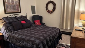 A bedroom with a bed, a chair, a desk, a lamp, a wall-mounted wreath, and a framed picture. - Hidden Valley - Walk to Slopes and Pool - 2 BR with Fireplace + WIFI (Hidden Valley)