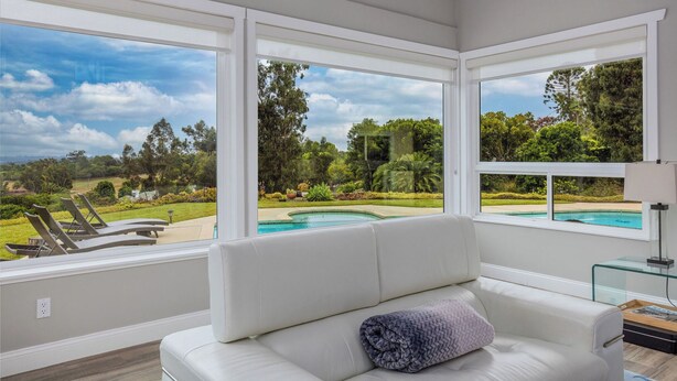 A modern living room with large windows overlooking a pool and garden. - Rancho Santa Fe Beauty, close to Del Mar Race Track & Riding Club (Rancho Santa Fe)