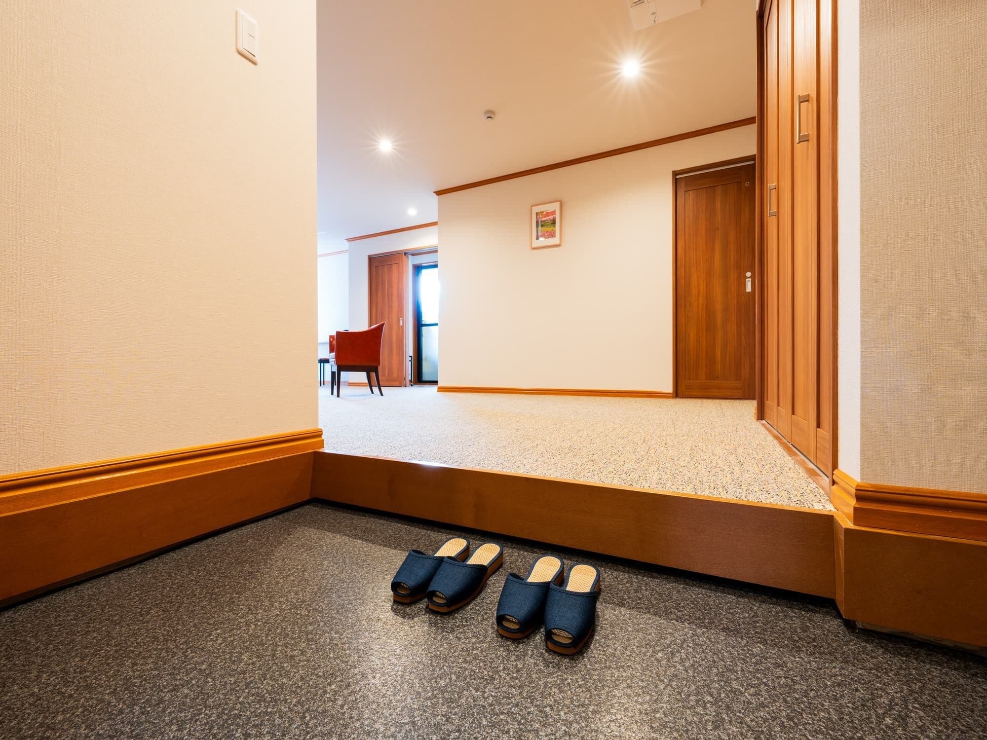 Un pasillo con piso alfombrado, paredes de madera y una puerta.