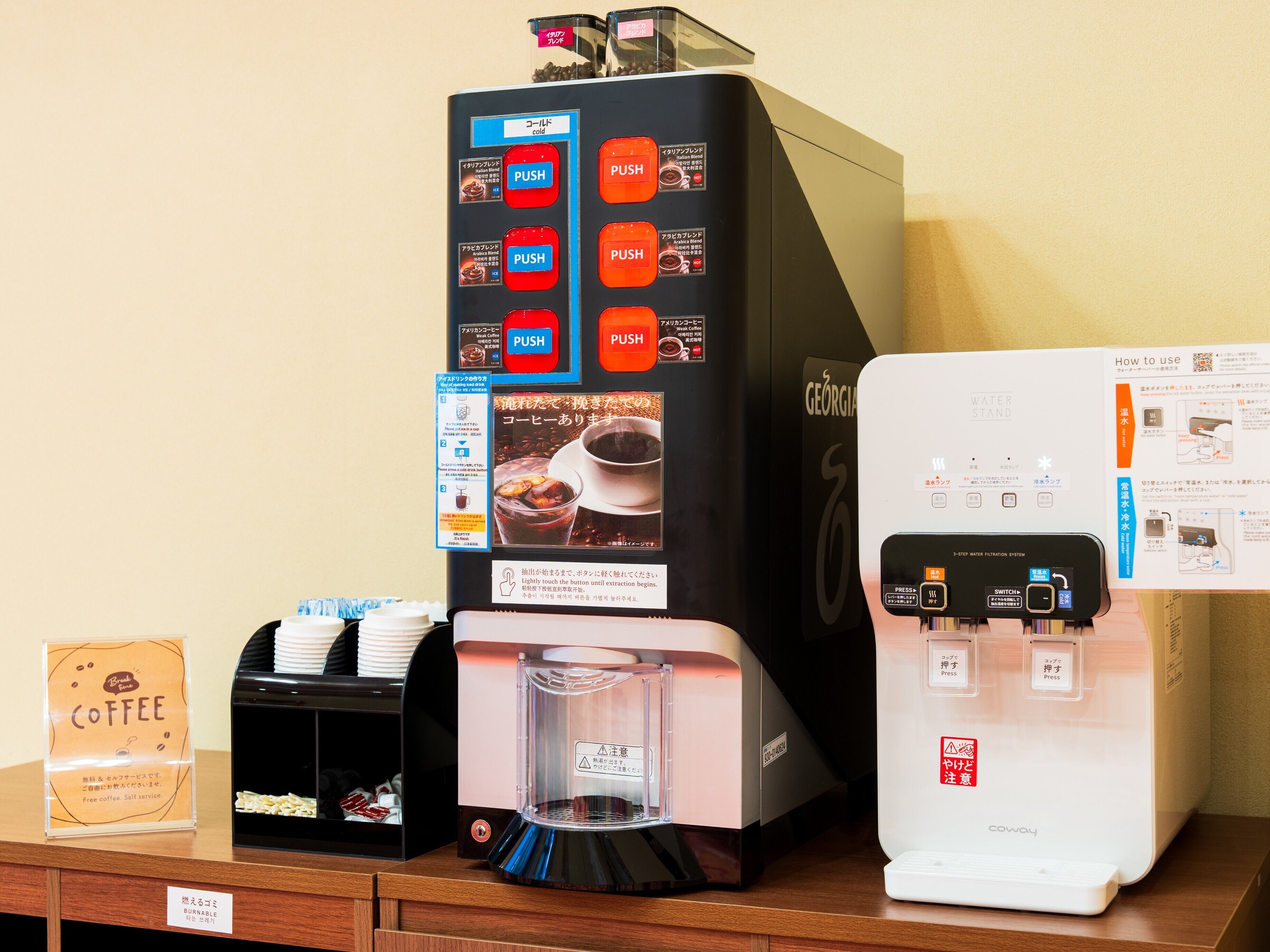 Máquina de café con varios botones para distintos tipos de café, dispensador de agua y calentador de tazas.