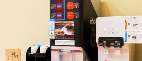 Máquina de café con varios botones para distintos tipos de café, dispensador de agua y calentador de tazas.
