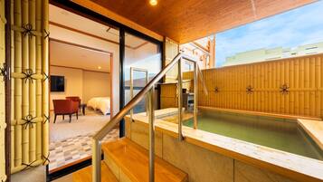 A modern hotel room with a wooden interior, a private bathroom, and a view of the cityscape.