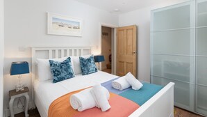 Et hotelværelse med en seng, en trædør og en glasgarderobe.